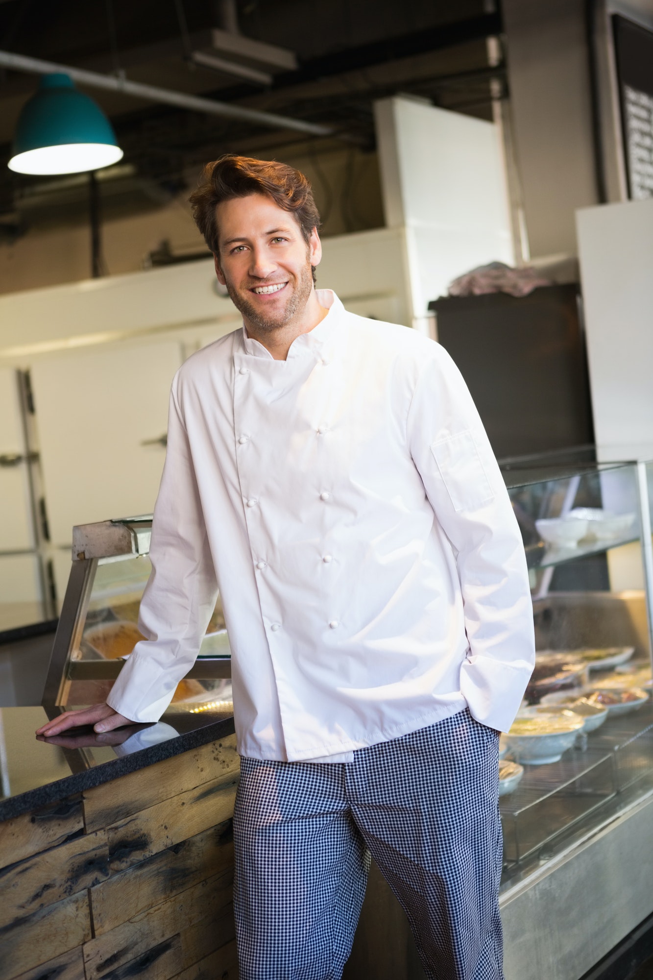 smiling-baker-leaning-on-counter-at-the-bakery.jpg